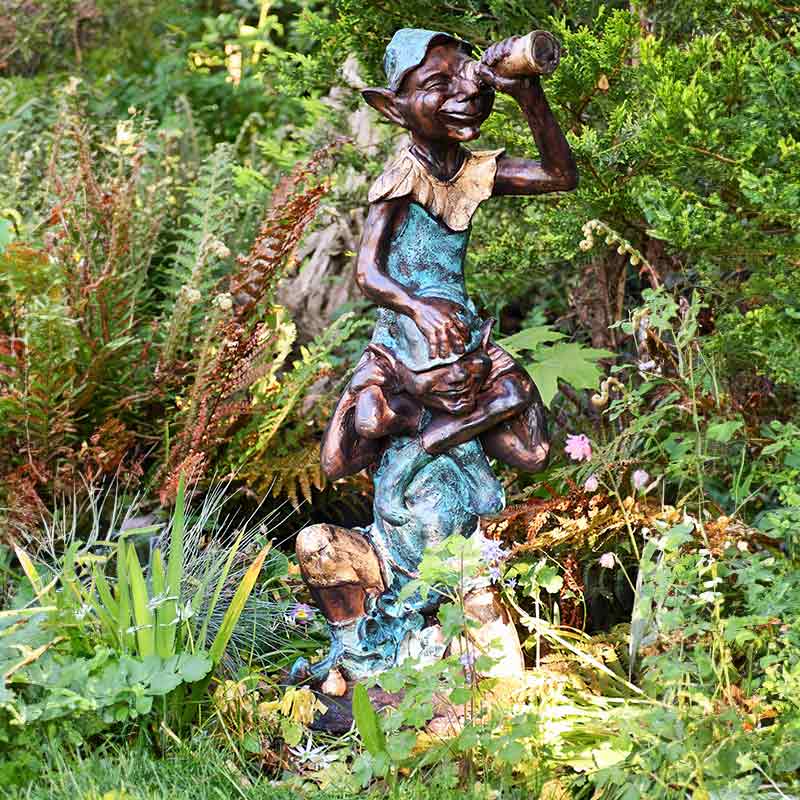 Home and Garden Pixie on shoulders garden statue with an aged green, gold and bronze paint finish.