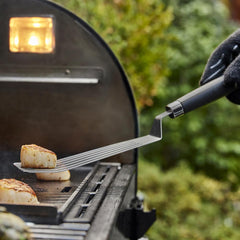 Weber Flexible Griddle Spatula in use lifting scallops from the griddle
