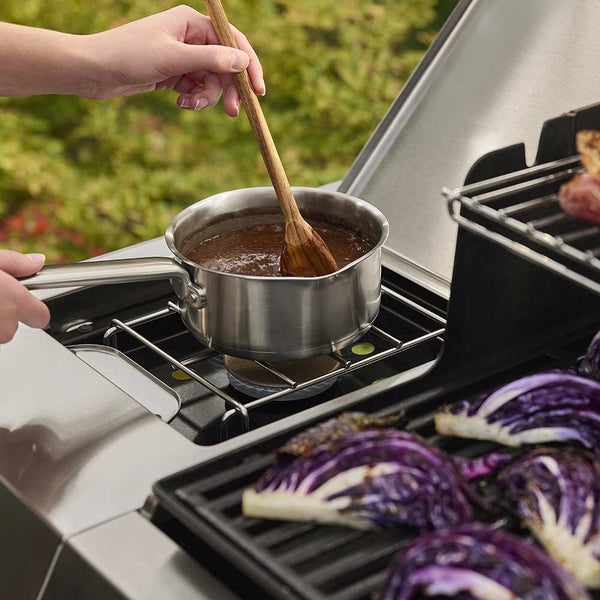 Stirring sauce on a Weber Genesis Gas Barbecue Side Burner
