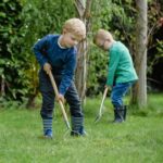 Child using the Kent & Stowe Kids Stainless Steel Garden Rake