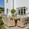Bramblecrest Chedworth Sandstone 8 Seat Dining Set with Kuta Table in garden