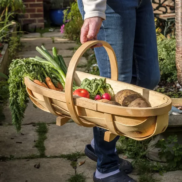 A man carrying vegetables in the large Burgon & Ball Traditional Wooden Trug.