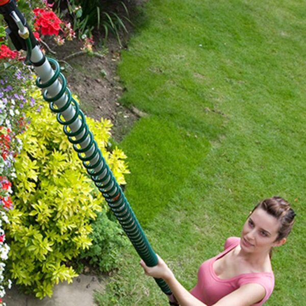 A woman holding the Darlac Telescopic Pole with the spiral hose coiled around it.