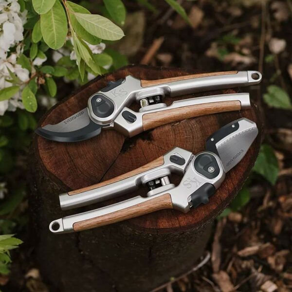 The Kent & Stowe Eversharp Anvil and Bypass Secateurs lying next to each other on a log.