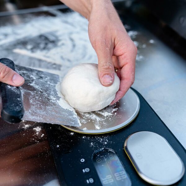Lifting dough using the Ooni Pizza Dough Scraper