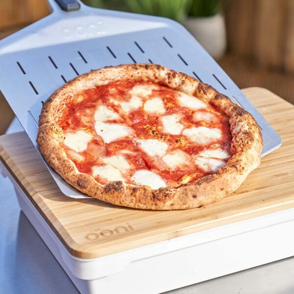 Ooni Pizza Prep Lid in use with cooked pizza