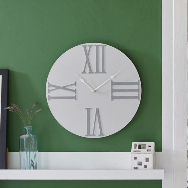 The Outside In Moda Cream Wall Clock in situ indoors on green wall