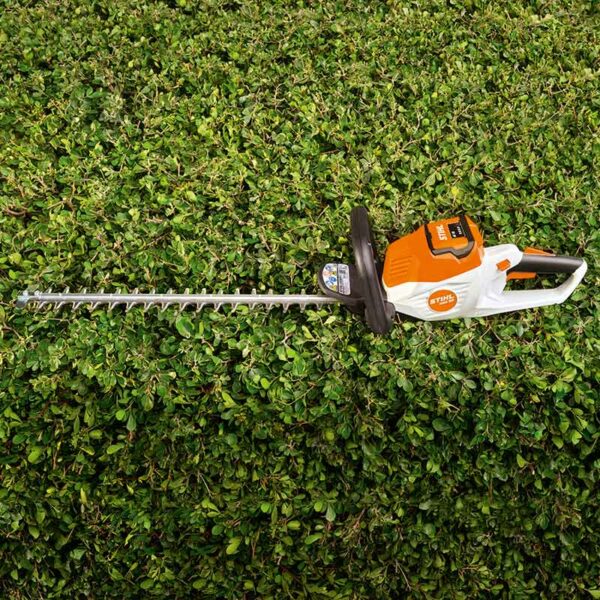 The STIHL HSA 50 Cordless Hedge Trimmer lying on a flat trimmed hedge.
