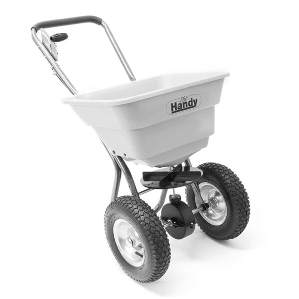 A heavy-duty, hand-pushed lawn spreader by Handy. It has large, rugged, off-road wheels and a white plastic basket.