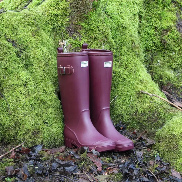 Town & Country Burford Wellington Boots aubergine against mossy tree