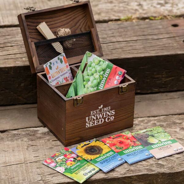 An open Unwins Gardeners' Seed Box displaying the contents including seed packets, twine, labels and a notebook.