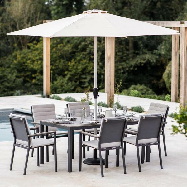 Bramblecrest Zurich 6 Seat Rectangular Dining Set with Parasol & Base on a patio